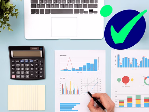 Office workspace with financial charts and laptop demonstrating the advantages of automating your bookkeeping